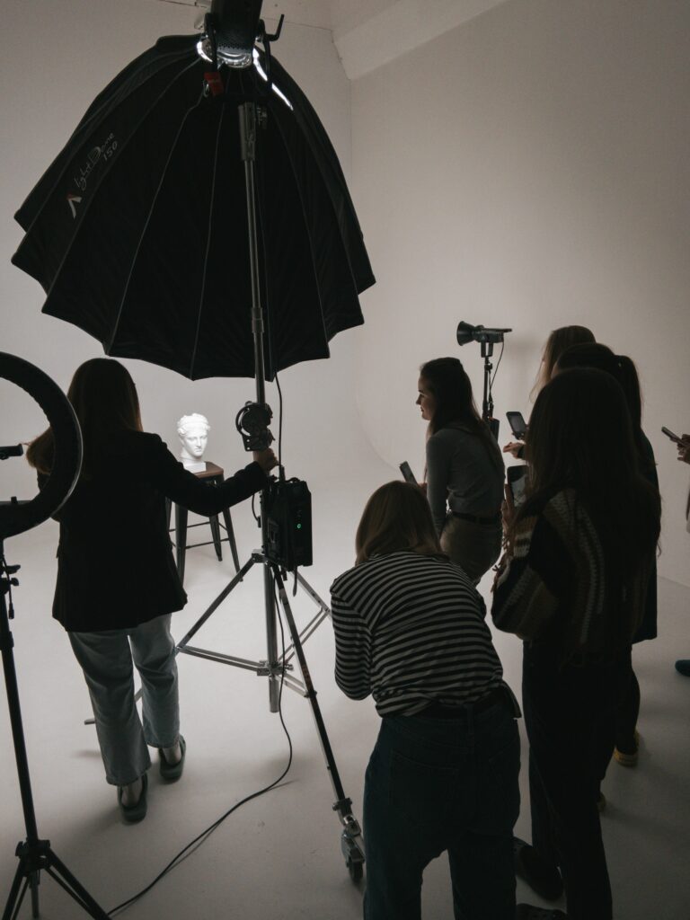 Studio d'une école de photographie professionnelle avec des étudiants ajustant le matériel d'éclairage