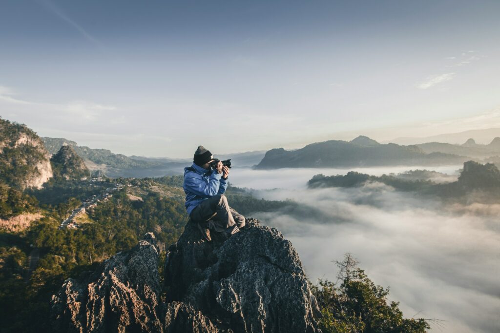 homme en train de photographier une vue de paysage en voyage