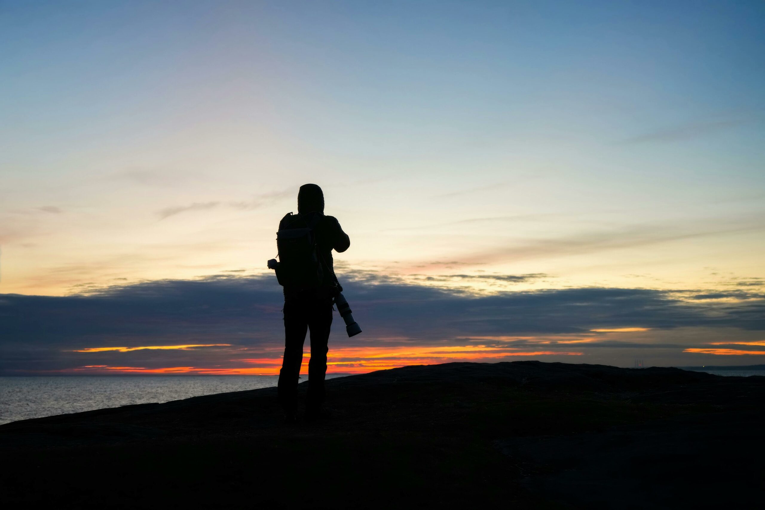 photographe en train de paramétrer son appareil pour faire une photographie de voyage